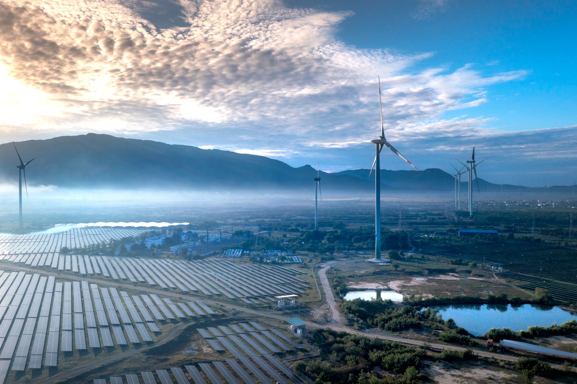 Stunning aerial view of wind turbines and solar panels in a landscape, showcasing renewable energy technologies.